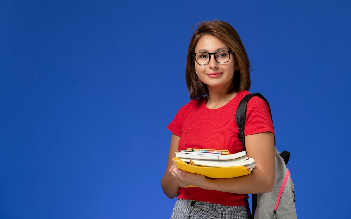 Smiling student holding books