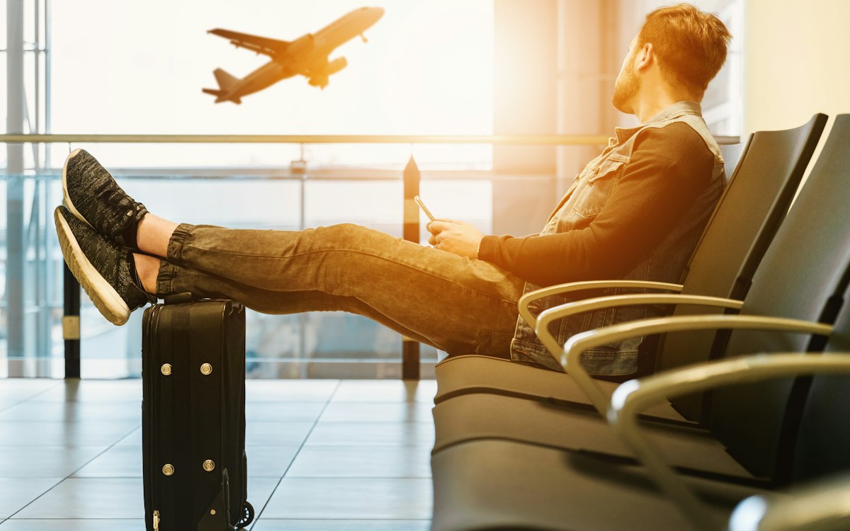 Traveller at an airport watching a plane take off