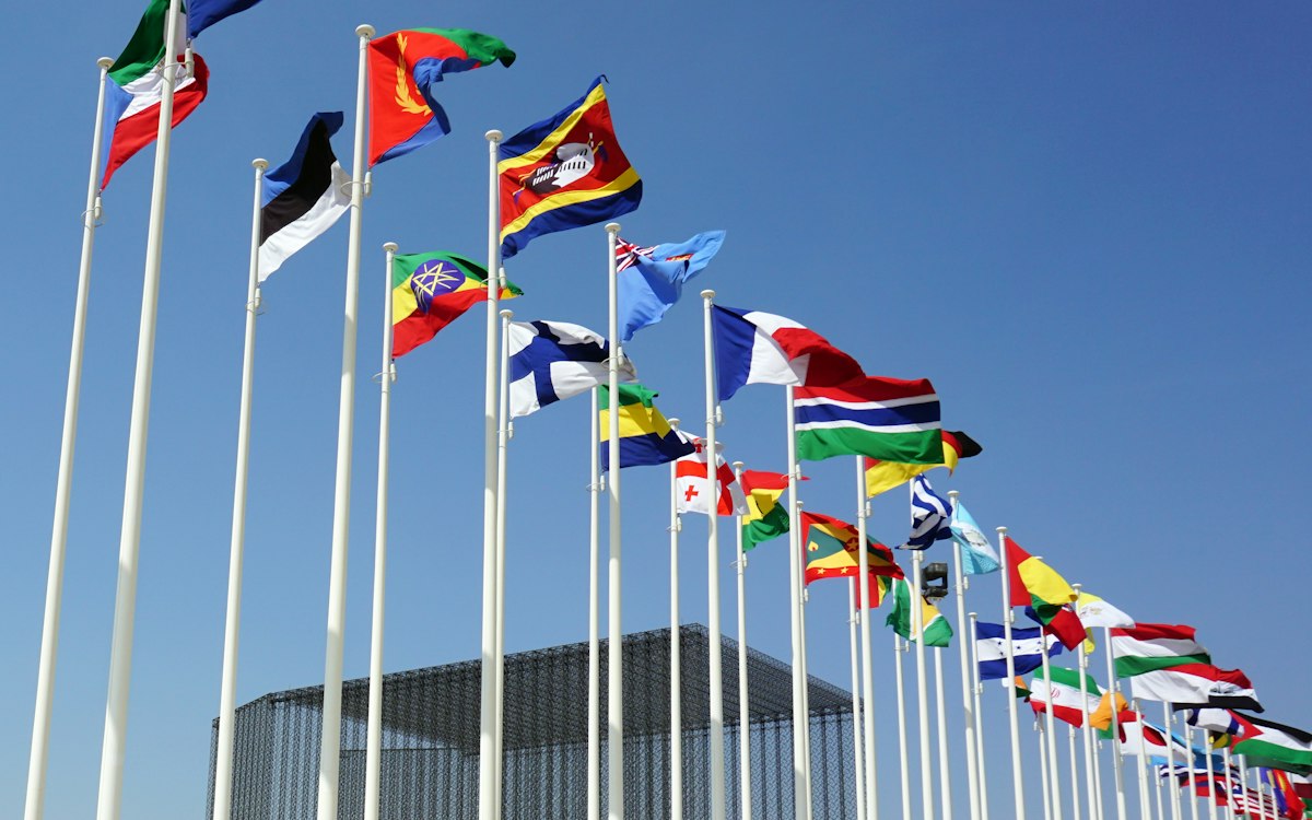 Flags of many countries against a blue sky