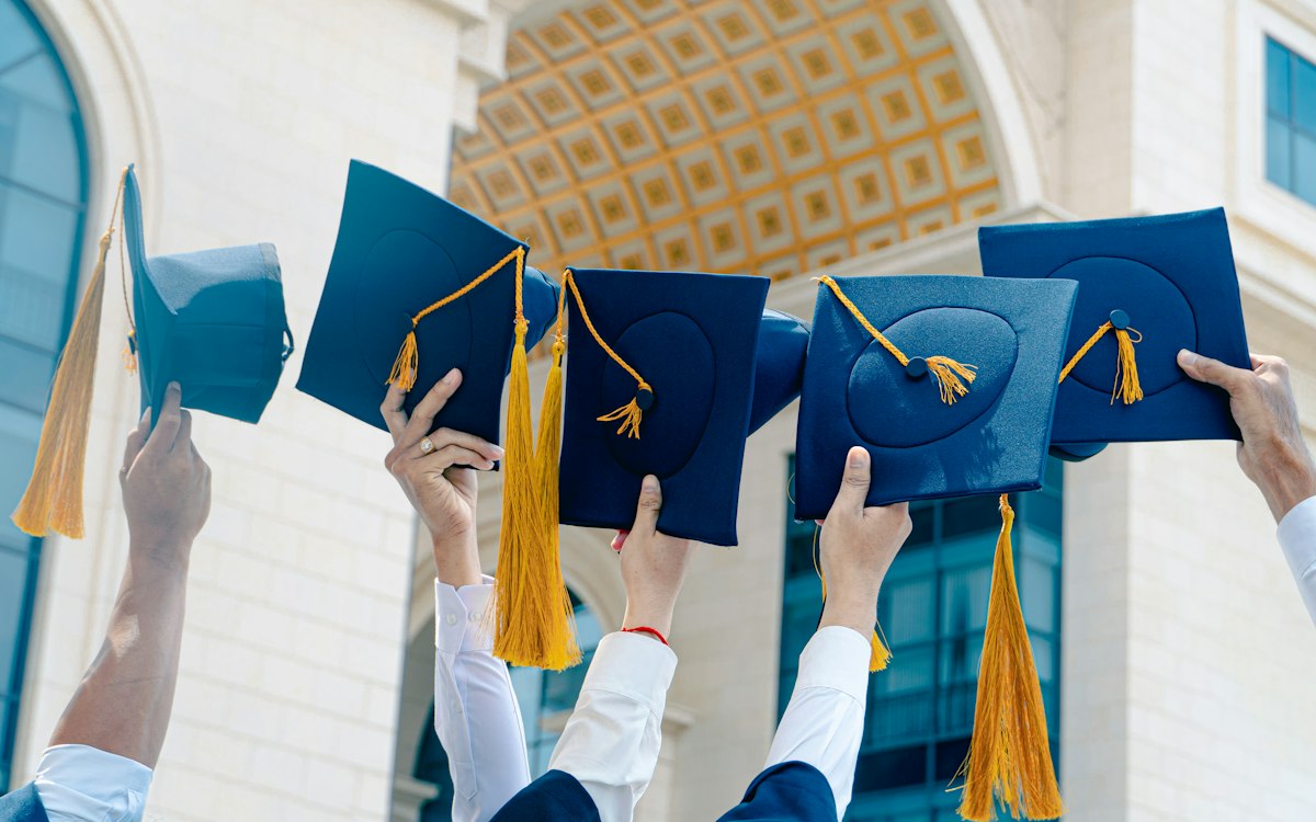 Graduates holding their caps in the air